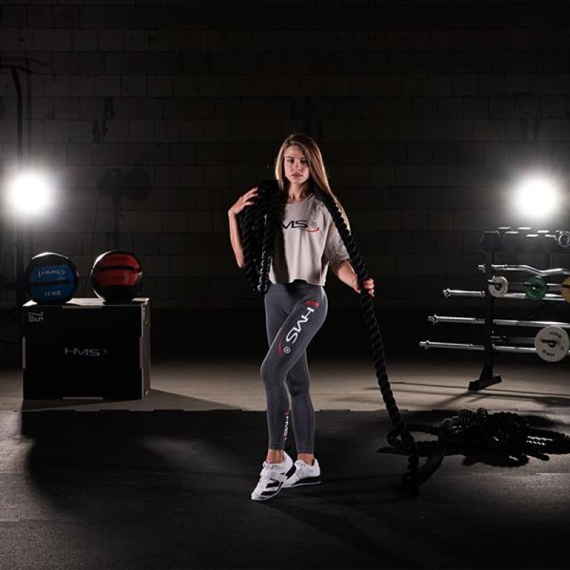 Női sportoló iFitCore battle rope kötéllel edzés közben, funkcionális edzőtermi környezetben