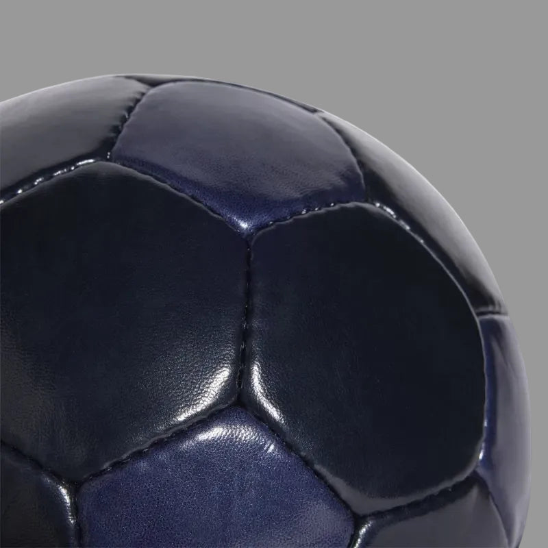 Gépi varrású szintetikus felület közelről: strapabíró, formatartó borítás, amely kiváló labdaérintést biztosít edzés közben.