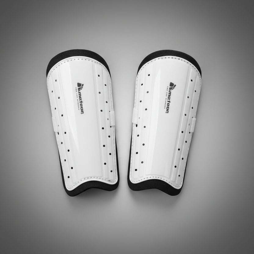 Meteor futball sípcsontvédő pár elölnézetben, fehér színben, ütésálló külső borítással és szellőzőnyílásokkal.